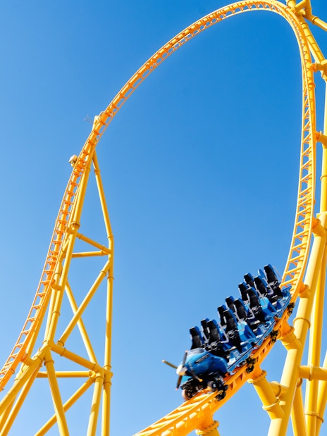 Roller coaster loop at Six Flags Qiddiya City against blue sky.